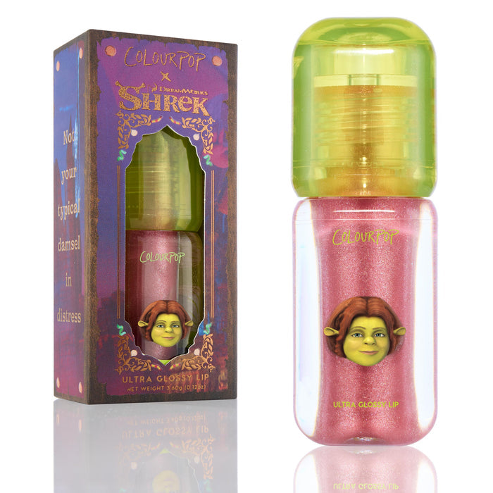 ColourPop Ultra Glossy Lip in Ogress shown upright with its box and bottle, a Shrek collab featuring Princess Fiona artwork; shimmery pink gloss in a clear rounded tube with a lime green cap on a white background.