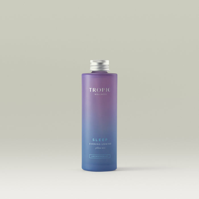 Tropic Evening Unwind Pillow Mist bottle with gradient purple design on a light gray background