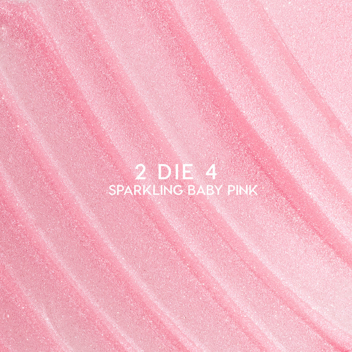Heart to Get 2 Die 4 ultra glossy lip swatch showing sparkling baby pink shimmer in diagonal, textured streaks against a smooth pastel background, highlighting the high-shine, glittery finish for US makeup lovers.