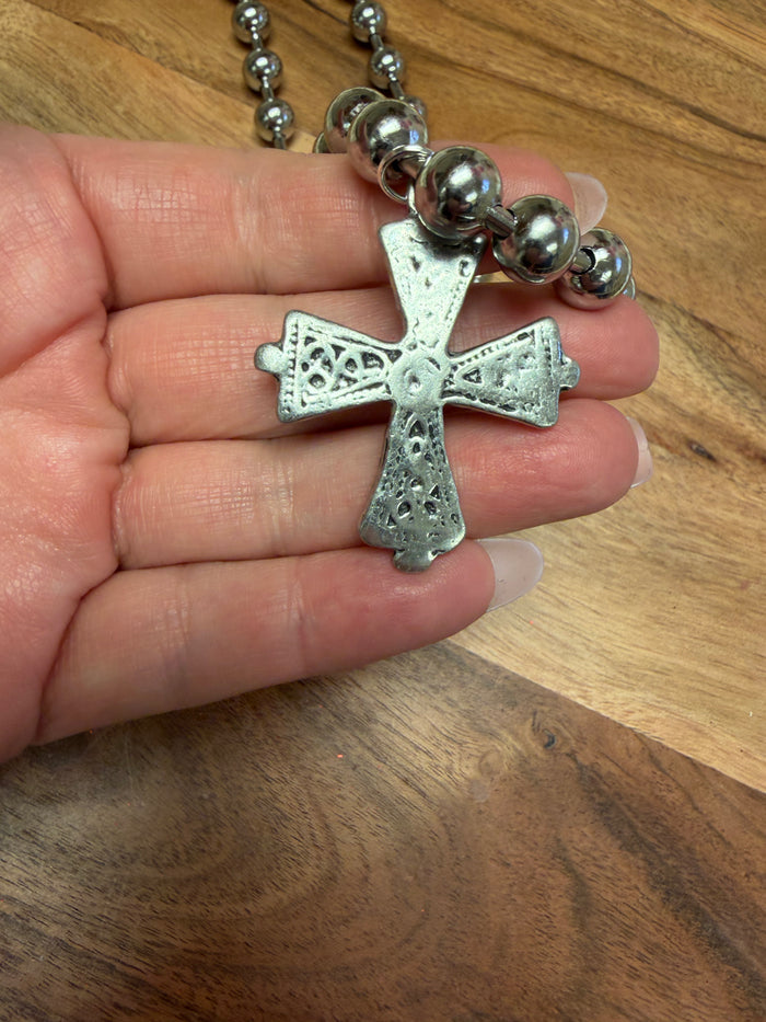 Lula 'n' Lee ball chain cross necklace hanging on a display, featuring a silver-tone metal cross on a ball chain necklace.