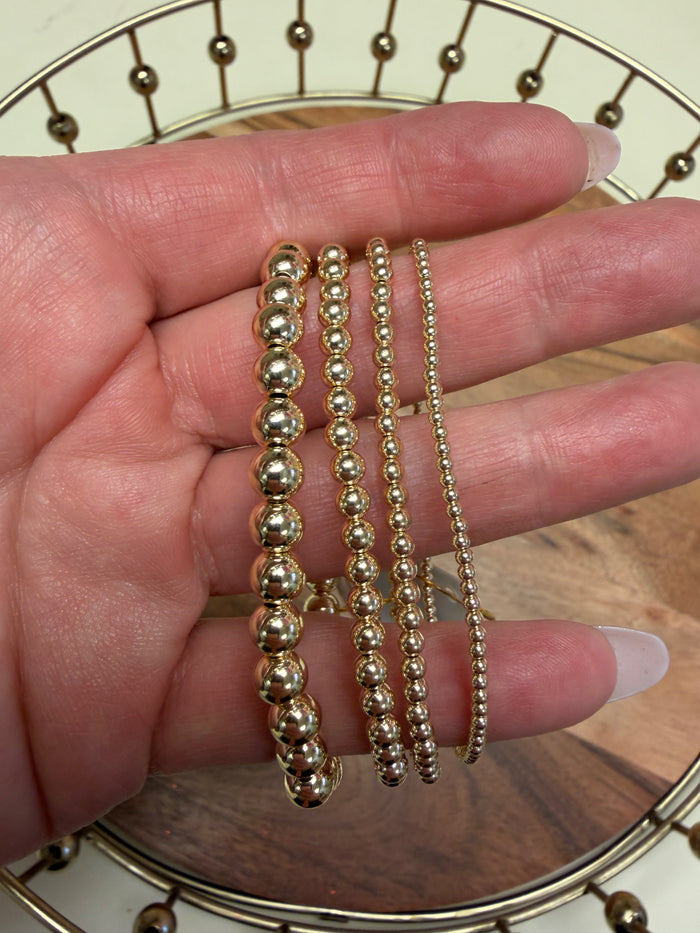 Gold filled beaded bracelet by Lula 'n' Lee, featuring small polished beads and a delicate clasp on a neutral background.
