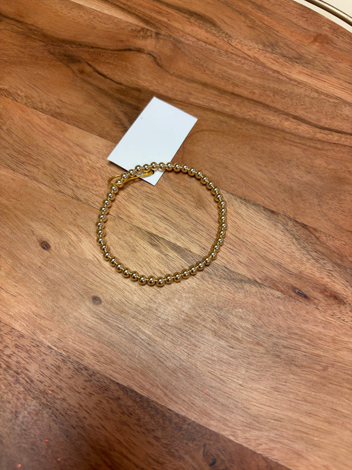 Gold filled beaded bracelet by Lula 'n' Lee featuring small, shiny beads on a delicate stretch bracelet design.