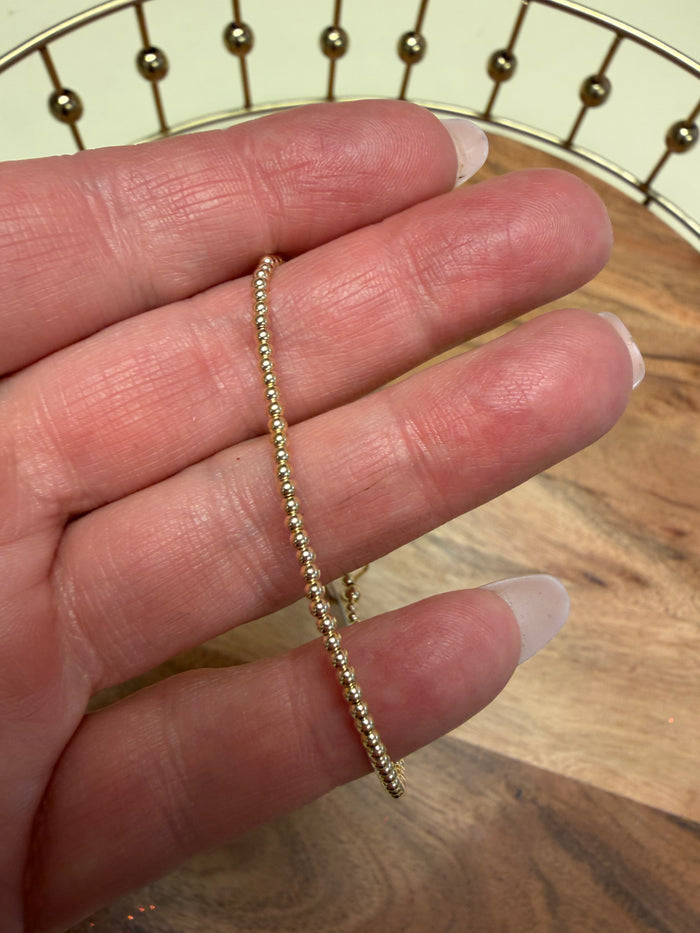 Gold filled beaded bracelet by Lula 'n' Lee featuring round beads on a delicate elastic band.