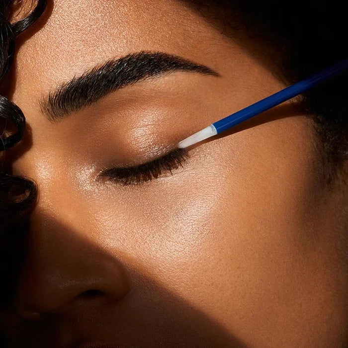 Applying eyebrow and lash enhancing serum with precision brush
