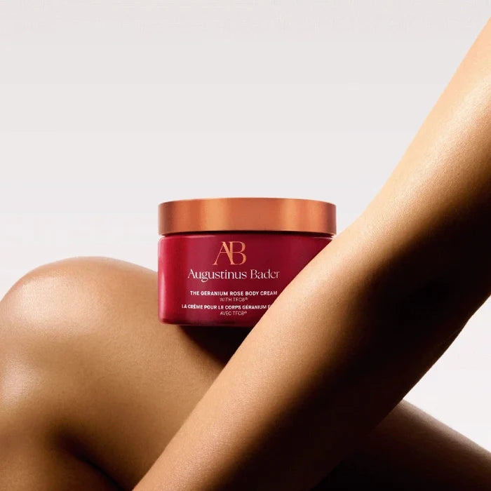 Augustinus Bader The Geranium Rose Body Cream jar on skin, copper lid and burgundy container