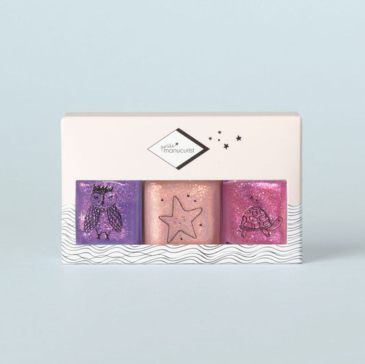 The Manucurist Betty Scarlett Stella Trio features three glittery, kid-safe, washable nail polishes in purple, peach, and pink with cute owl, starfish, and turtle designs. Packaged in a white box for creative fun!.