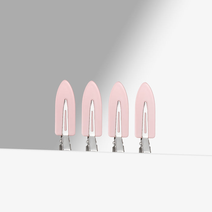 Four pink hair clips on a white background