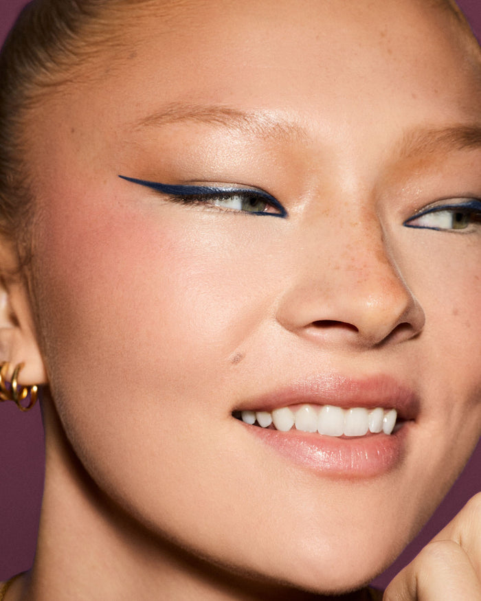 Model wearing Fine Linez Lash-Enhancing Eyeliner in shade 'The Navy'.