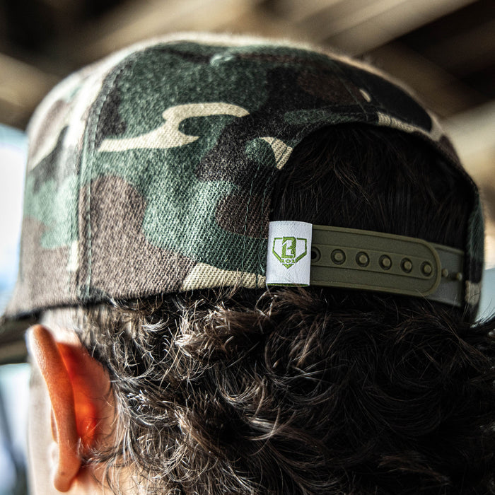 Camouflage snapback hat with white embroidered BL101 shield logo design on the front