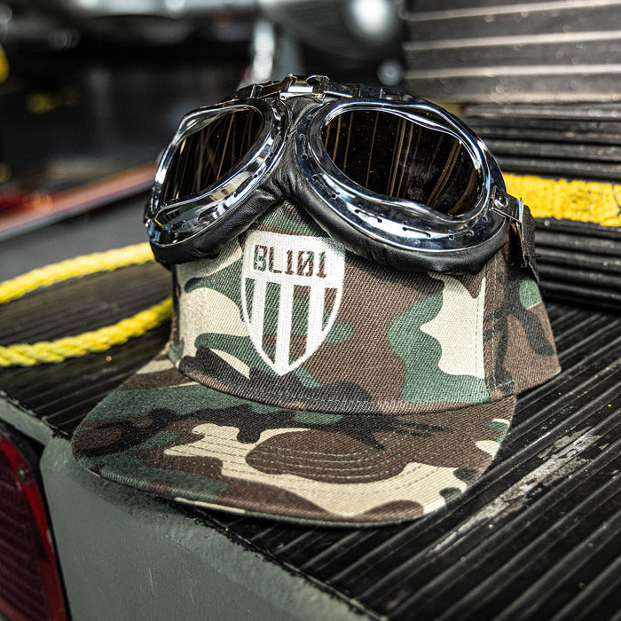 Camouflage snapback hat with white embroidered BL101 shield logo design on the front