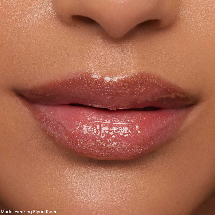 Glossy nude-pink lips wearing ColourPop Ultra Glossy Lip in Flynn Rider, reflecting a high-shine finish with subtle shimmer in a tight face close-up, showcasing smooth, hydrated texture for everyday wear.