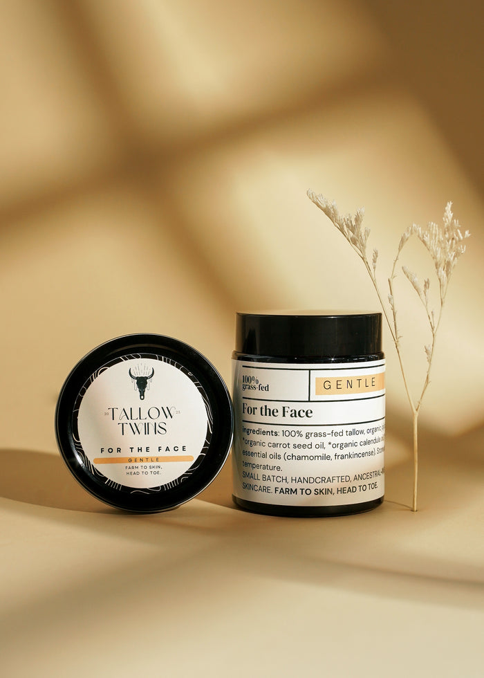 A jar of For the Face Gentle moisturiser and its lid beside a dried flower stem.