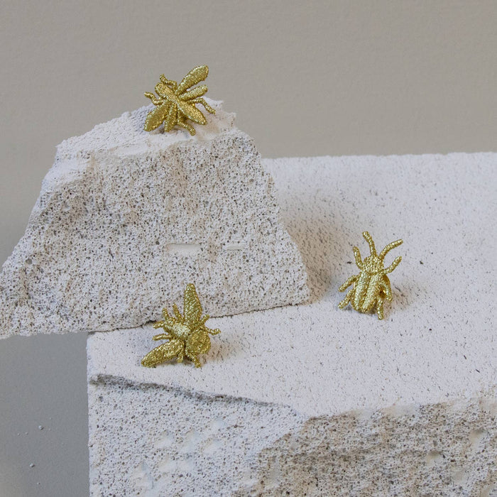 Golden embroidered bug pins featuring three tiny insect designs, perfect for plant lovers' decor or accessories.