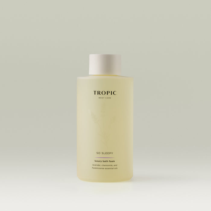Tropic So Sleepy Luxury Bath Foam bottle featuring a soft yellow formula, minimalist design, and subtle botanical illustration, containing lavender, chamomile, and frankincense essential oils.