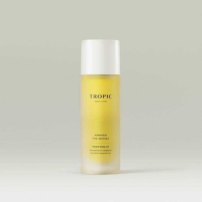 Tropic Awaken The Senses luxury body oil with macadamia oil, bergamot, and neroli essential oils in a sleek frosted bottle.