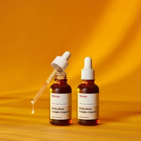 ma:nyo Bifida Biome Complex Ampoule 50ml bottles with droppers on a vibrant yellow background.