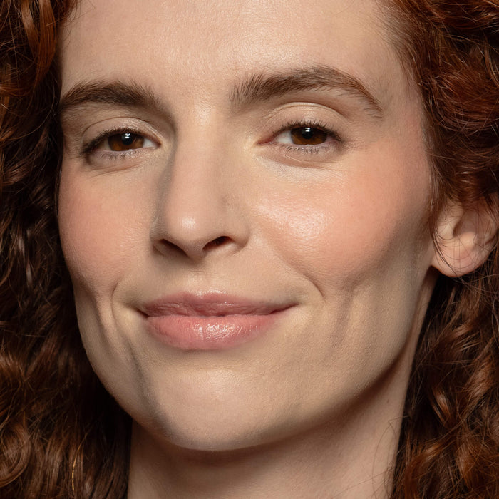 No Makeup Makeup – Close-up of a woman wearing peach blush on cheek and lip, natural minimal makeup