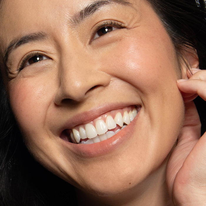 No Makeup Makeup – Close-up of a woman wearing peach blush on cheek and lip, natural minimal makeup