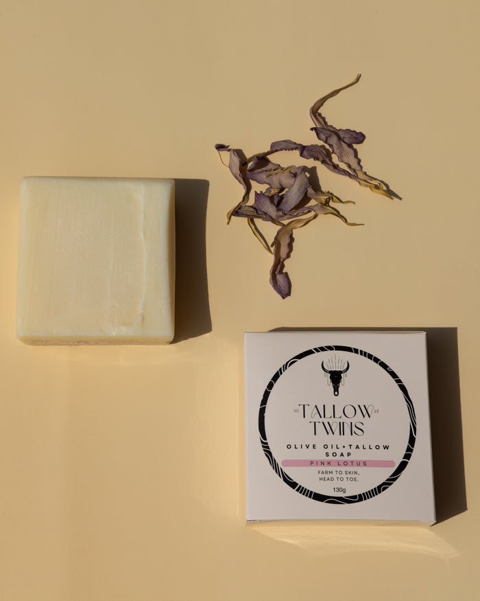 Pink Lotus olive oil and tallow soap bar beside its box, with dried lotus petals.