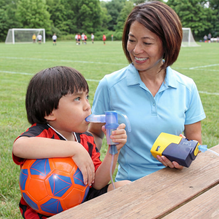 A child Using a Pari Trek S Portable Nebulizer Compressor