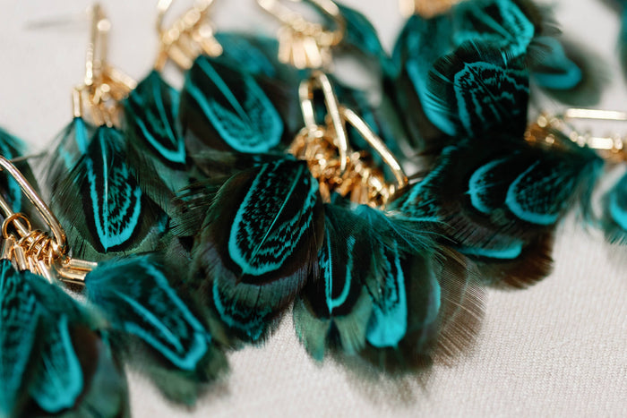 Peacock feather statement tassel earrings featuring vibrant feathers and elegant design, by St Armands Designs of Sarasota.