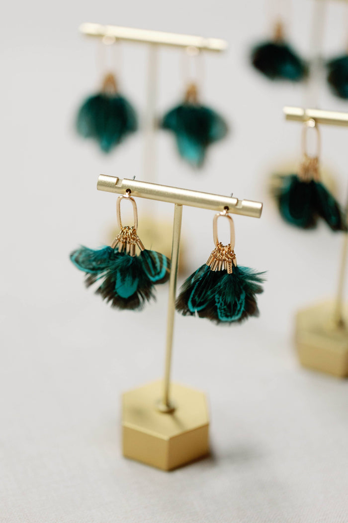 Peacock feather statement tassel earrings with vibrant feathers and gold accents, designed by St Armands Designs of Sarasota.