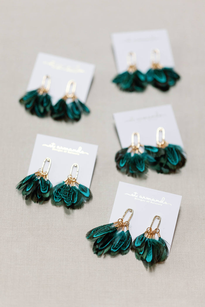 Peacock feather statement tassel earrings by St Armands Designs of Sarasota, featuring vibrant feathers and elegant dangle style.