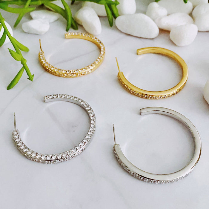Reversible Ellison+Young hoop earrings featuring a plain and shiny finish, shown in a close-up image highlighting their design.
