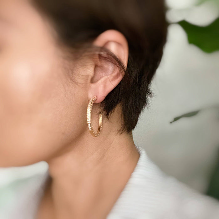 Reversible hoop earrings by Ellison+Young featuring a plain and shiny finish, shown in a close-up on a model's ear.