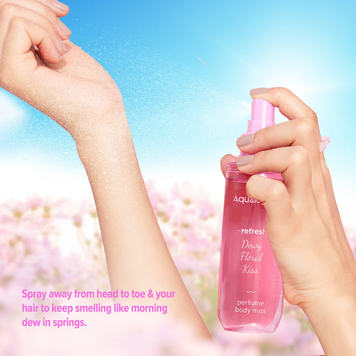 Hand spraying floral body mist with a dewy finish