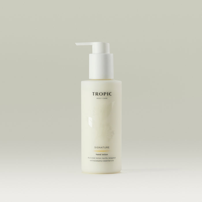 Tropic Signature Hand Lotion in a sleek frosted bottle with a white pump dispenser, displayed against a neutral background.