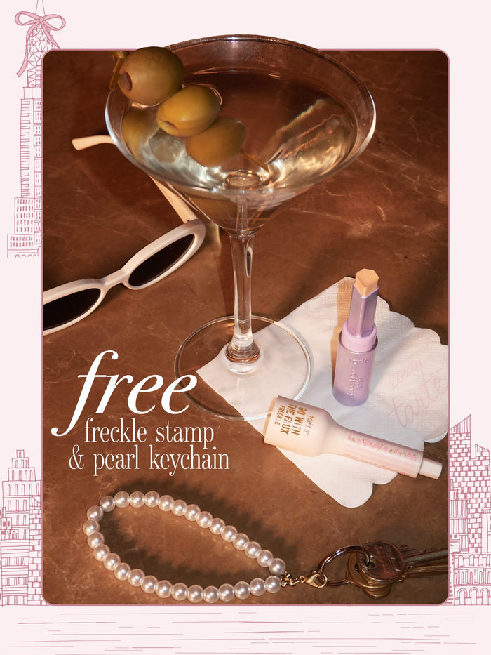A flat-lay featuring a pearl keychain attached to keys, alongside a martini, sunglasses, shape tape blur stick and go with the faux freckle stamp. 'free freckle stamp & pearl keychain'