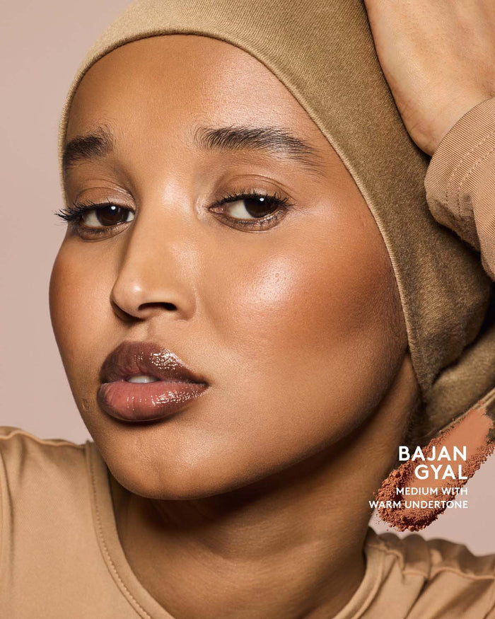 Medium skin tone model wearing sun stalk'r bronzer in shade Bajan Gyal.