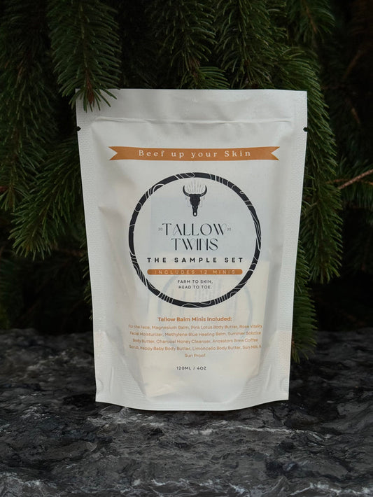 The Tallow Twins Sample Set pouch, containing twelve balm minis, against evergreen branches.