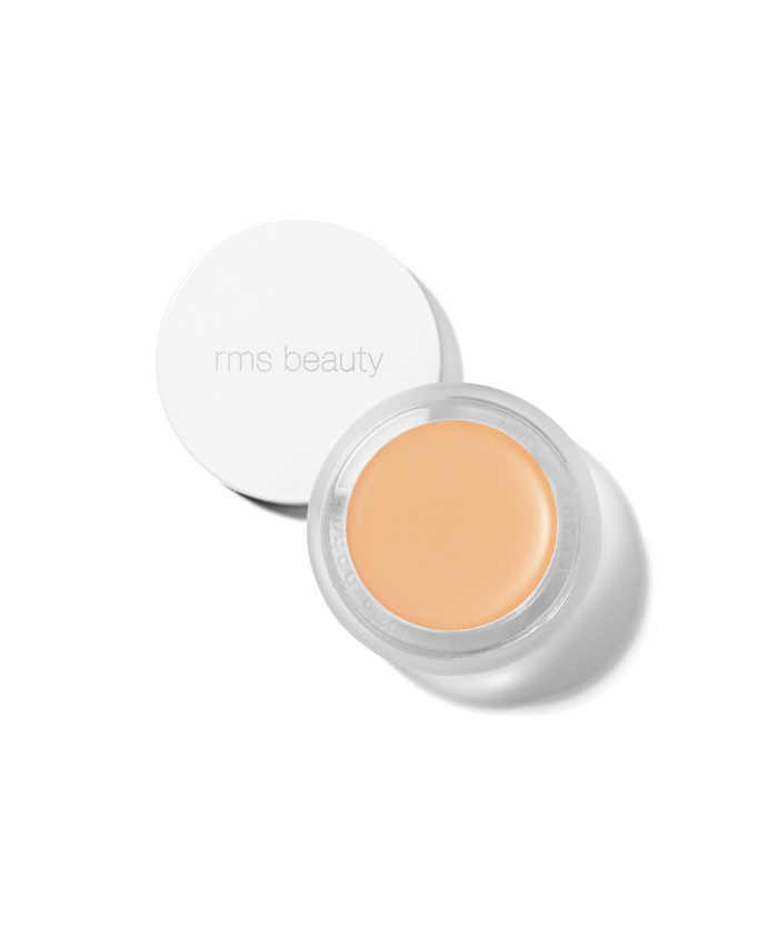 Open jar of UnCoverup Concealer showing natural beige cream formula with white lid embossed rms beauty, highlighting clean beauty and skincare infused makeup.